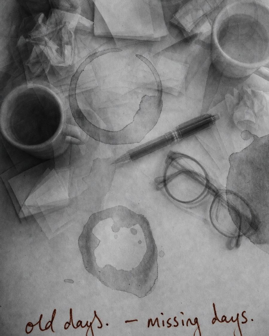 흑백 책상 위 머그잔, 펜, 안경과 커피 자국. 아래에 붉은 손글씨로 old days. — missing days.